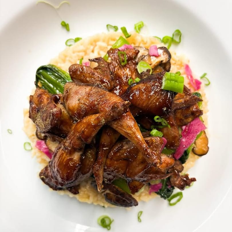Braised quail with bok choy, pickled onions, and mushrooms over a bed of creamy risotto.